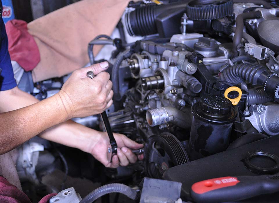 image of mechanic's hands working on a car at Masaki's Automotive